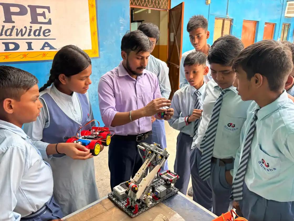 Indian students building robotics kits with a trainer