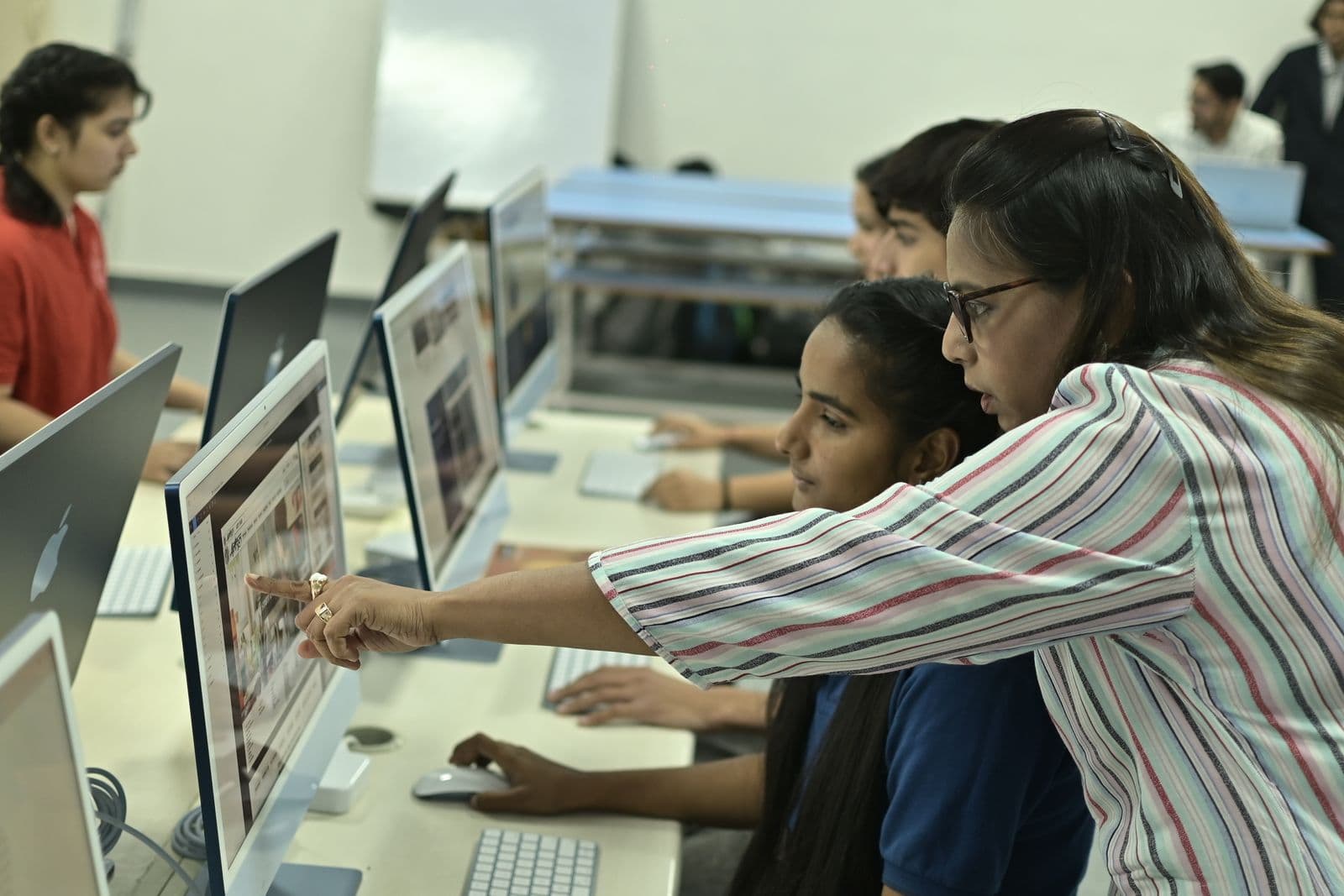 Indian students learning with a teacher in a computer lab